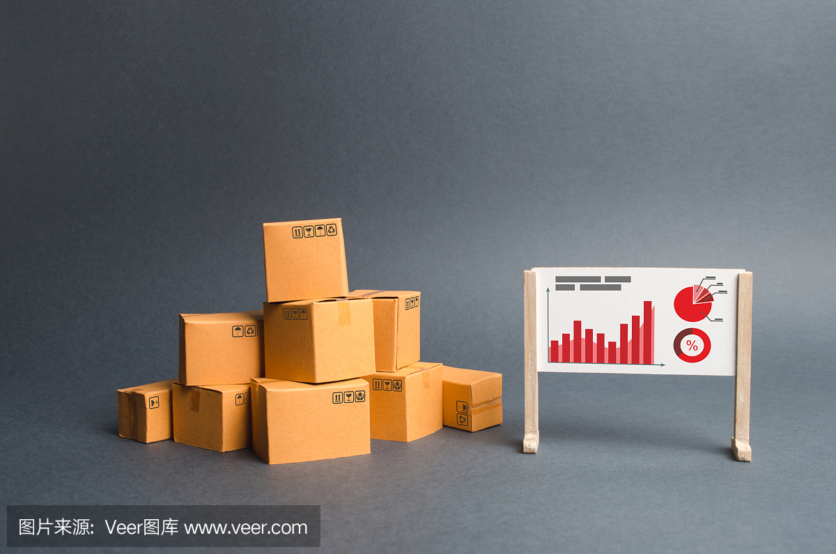 一堆纸箱和一个有信息和统计图表的展台。关于货物的生产和销售速度、经济增长和供求评估的报告。业务。